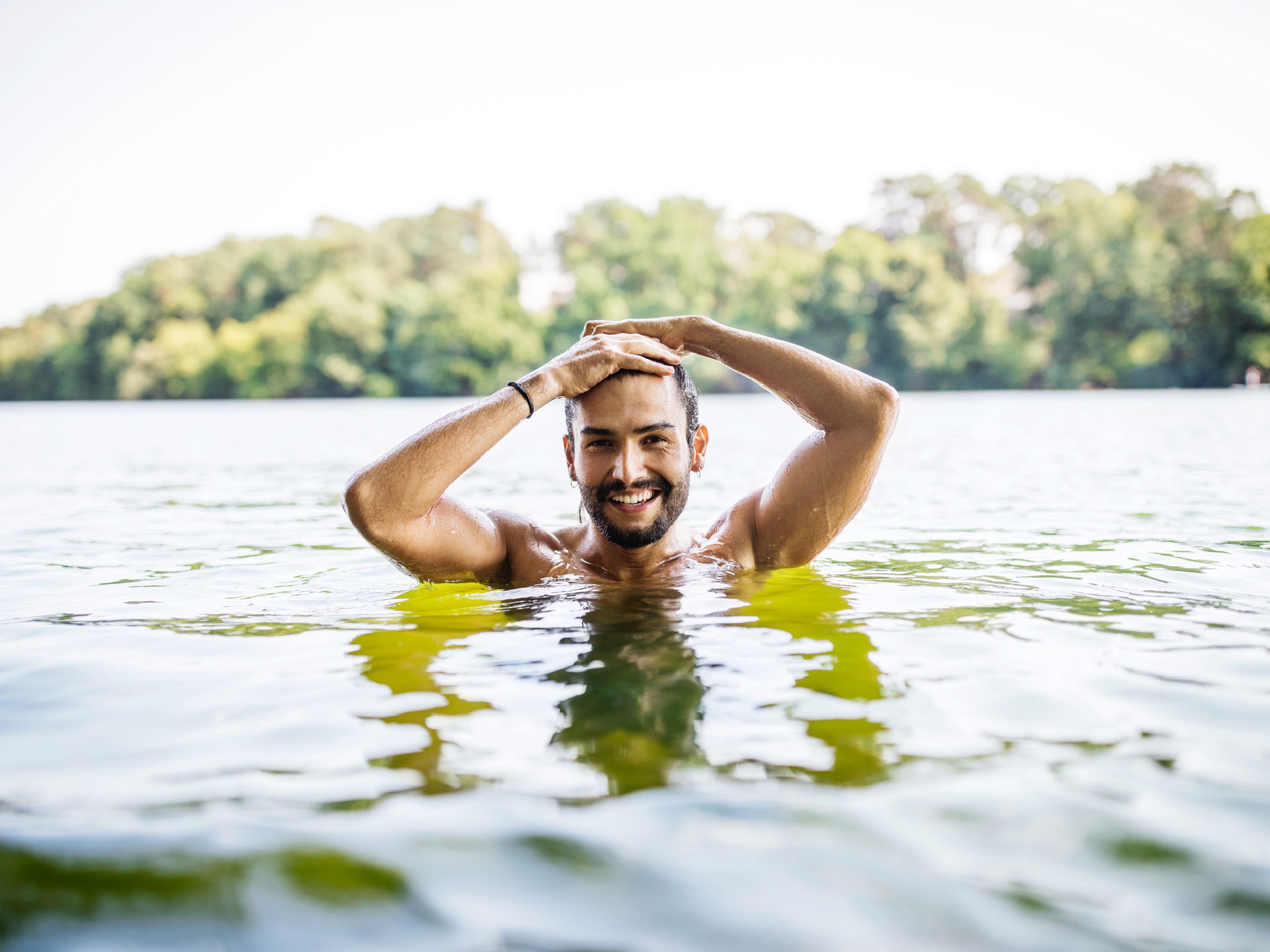 Content Hautkrebs junger Mann schwimmt im See