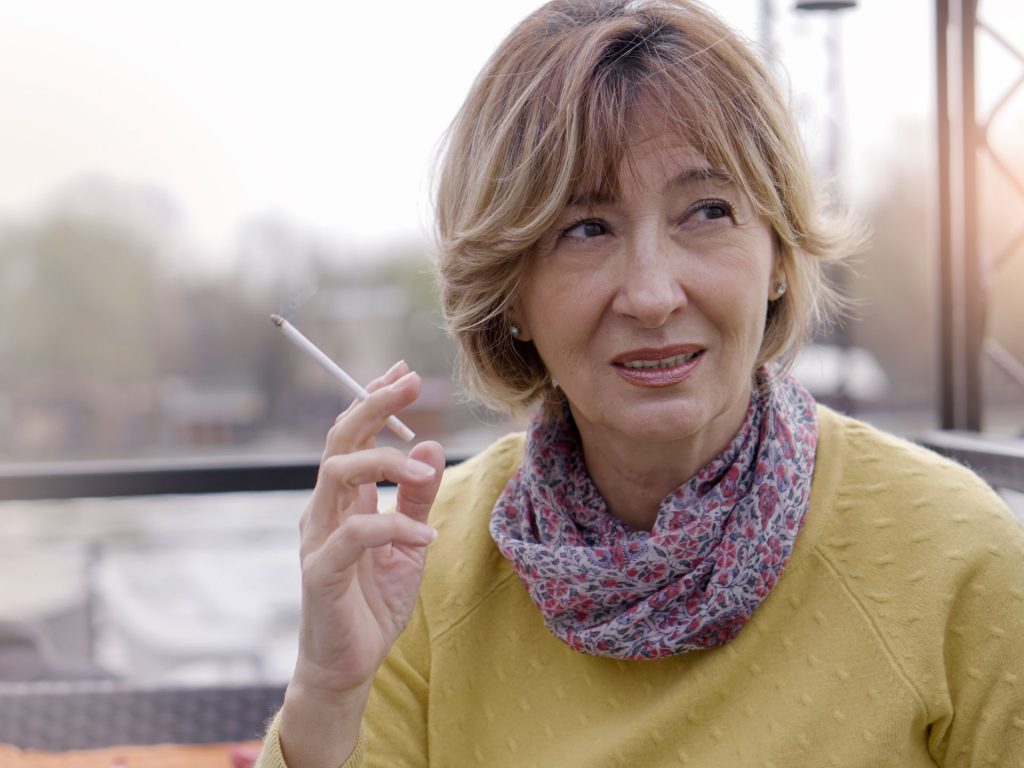 Frau mit Arthrose raucht