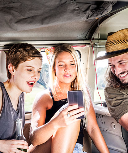 Junge Leute mit Handy im VW-Bus
